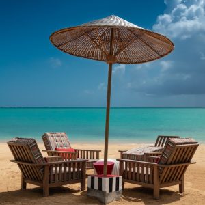 brown wooden 5-piece patio set on sand during daytime