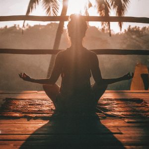 woman doing yoga meditation on brown parquet flooring