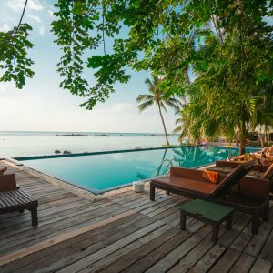 brown wooden table and chairs on brown wooden deck near body of water during daytime