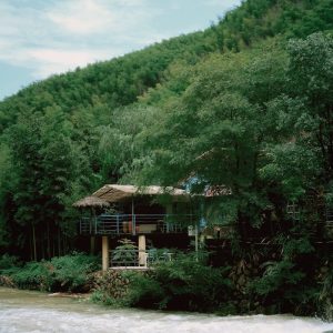 a house sitting on top of a lush green hillside